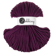 A skein of 5mm braided cord in a deep plum purple aubergine color, wrapped with a white paper label that reads 'Bobbiny'.
