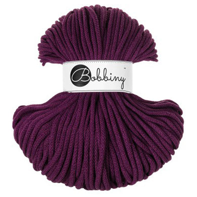 A skein of 5mm braided cord in a deep plum purple aubergine color, wrapped with a white paper label that reads 'Bobbiny'.