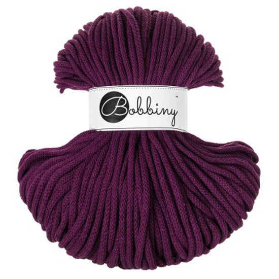 A skein of 5mm braided cord in a deep plum purple aubergine color, wrapped with a white paper label that reads 'Bobbiny'.