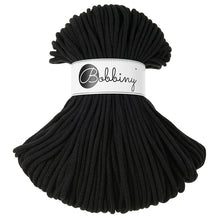 A bundle of black braided rope or cord with a white paper label around the middle that reads 'Bobbiny'.