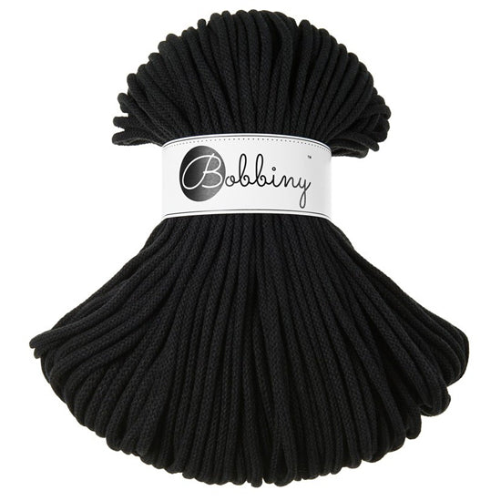 A bundle of black braided rope or cord with a white paper label around the middle that reads 'Bobbiny'.
