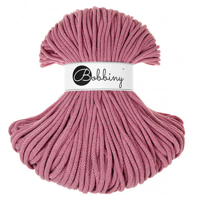 A skein of blossom pink braided rope  with a white paper label in the center that reads 'Bobbiny' in black script and logo, set against a plain white background.