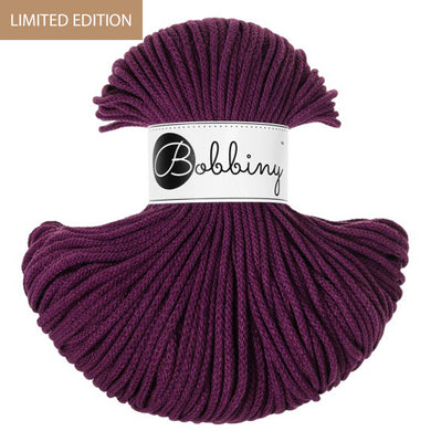 A skein of Bobbiny yarn in a deep plum color, featuring a white paper label with the brand name 'Bobbiny' and a brown 'LIMITED EDITION' banner in the top left corner.