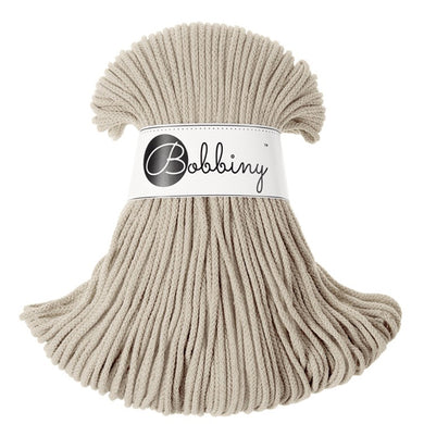 A skein of light beige braided cord with a white paper band in the center featuring the black script logo 'Bobbiny'.