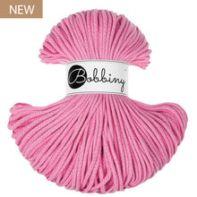 A skein of pink Bobbiny yarn with a white paper label in the center, shown on a plain white background with a small 'NEW' badge in the top-left corner.