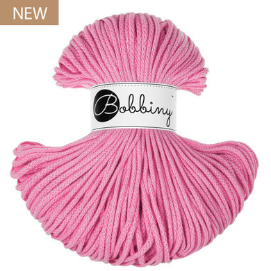A skein of pink Bobbiny yarn with a white paper label in the center, shown on a plain white background with a small 'NEW' badge in the top-left corner.