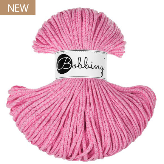 A skein of pink Bobbiny yarn with a white paper label in the center, shown on a plain white background with a small 'NEW' badge in the top-left corner.