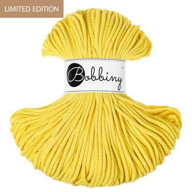 A skein of bright yellow Bobbiny cord with a white paper label in the center, shown on a plain white background with a brown 'LIMITED EDITION' banner in the top-left corner.