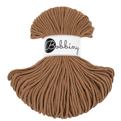 A skein of caramel bobbiny cord with a white paper label that reads 'Bobbiny' in black script, set against a plain white background.