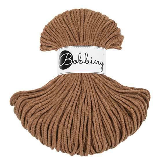 A skein of caramel bobbiny cord with a white paper label that reads 'Bobbiny' in black script, set against a plain white background.