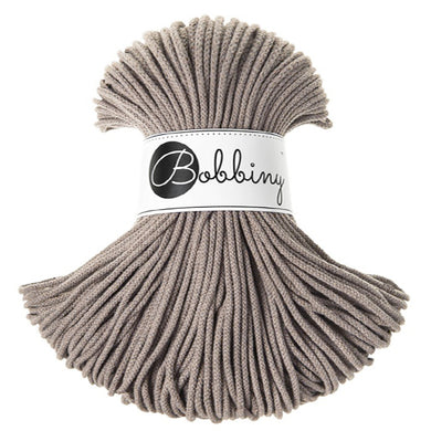 A skein of coffee coloured braided cord wrapped with a white paper band labeled 'Bobbiny' in black script and logo, set against a plain white background.