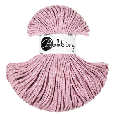 A skein of dusty pink braided cord with a white paper label in the center that reads 'Bobbiny' in black script and logo, set against a plain white background.