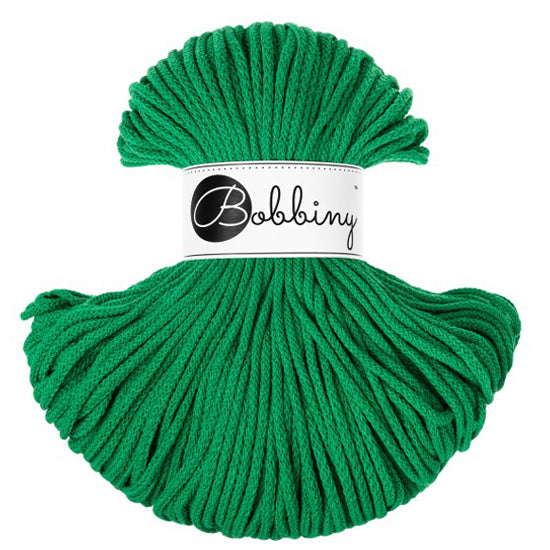 A skein of bright green braided cord  with a white paper label in the center that reads 'Bobbiny' in black script and logo, shown on a plain white background.