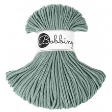 A skein of laurel green braided cord with a white paper label in the center that reads 'Bobbiny'.