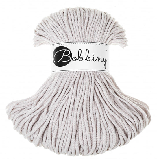 A skein of light gray braided cord with a white paper band around the middle that reads 'Bobbiny' in black script and logo, photographed on a plain white background.