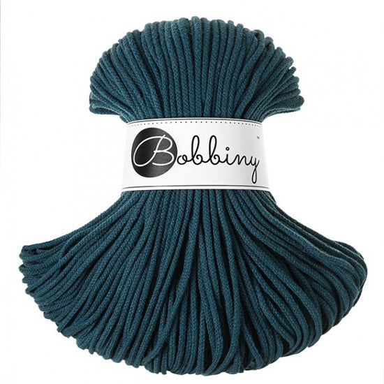 A skein of dark teal braided cord with a white paper label that reads 'Bobbiny' in black script, set against a plain white background.