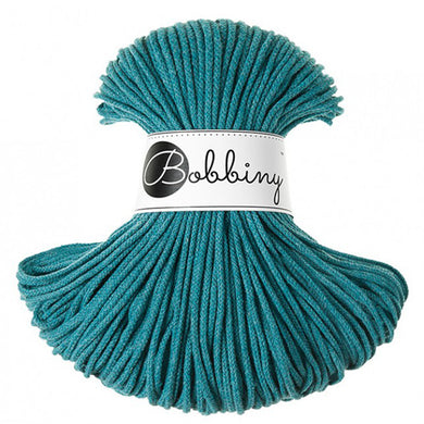 A skein of teal braided cord with a white paper label wrapped around the middle that reads 'Bobbiny'.