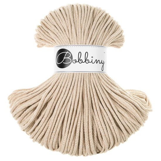 A bundle of beige braided cord with a white paper label in the center that reads 'Bobbiny' in black script and logo, set against a plain white background.