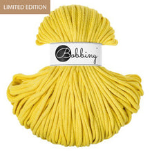 A skein of bright yellow Bobbiny yarn with a white paper label band in the center, set against a plain white background. A brown banner in the top-left corner reads 'LIMITED EDITION'.