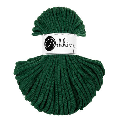 A skein of dark green braided cord with a white paper label wrapped around the center that reads 'Bobbiny' in black script.