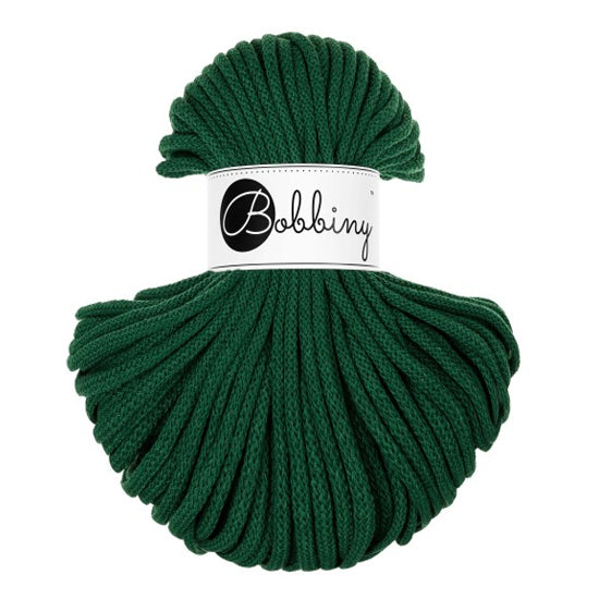 A skein of dark green braided cord with a white paper label wrapped around the center that reads 'Bobbiny' in black script.