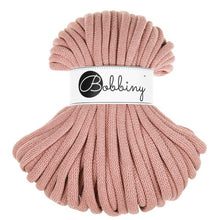 A skein of blush pink chunky braided cord wrapped with a white paper label that reads 'Bobbiny'.