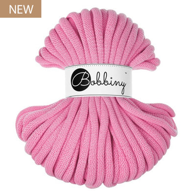 A skein of pink braided cord with a white paper band labeled 'Bobbiny' in script, shown on a plain white background with a small 'NEW' badge in the top-left corner.