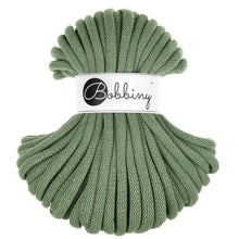 A skein of eucalyptus green braided cord with a white paper label in the center that reads 'Bobbiny' in black script and logo, set against a plain white background.