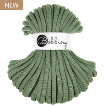 A skein of eucalyptus green braided cord with a white paper label reading 'Bobbiny' in black script, shown on a plain white background with a small 'NEW' badge in the top-left corner.