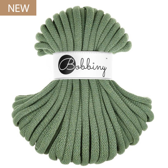 A skein of eucalyptus green braided cord with a white paper label reading 'Bobbiny' in black script, shown on a plain white background with a small 'NEW' badge in the top-left corner.