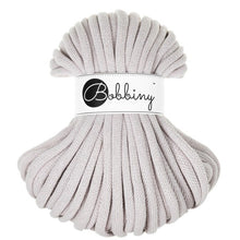 A skein of light silver braided cord with a white paper label in the center that reads 'Bobbiny' in black script and logo, set against a plain white background.