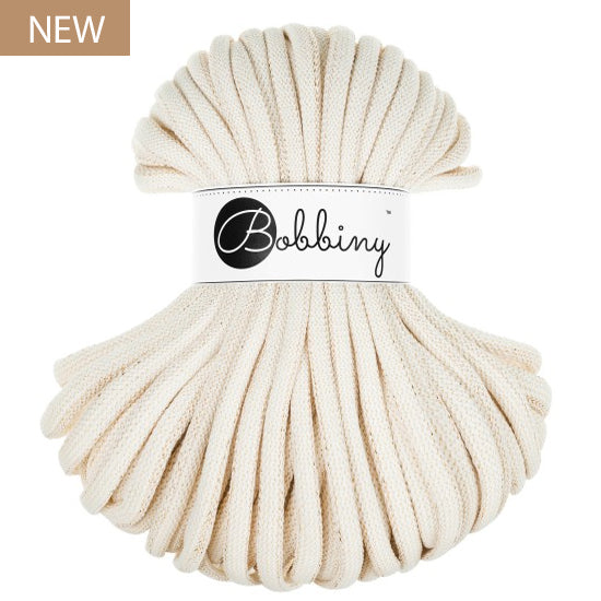 A skein of thick, natural colored braided cord with a white paper label in the center that reads 'Bobbiny'. A small brown 'NEW' label is in the top-left corner.