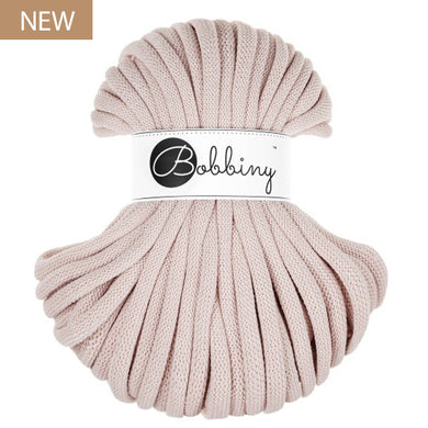 A skein of nude braided cord with a white paper label reading 'Bobbiny' in black script, shown on a plain white background with a small 'NEW' badge in the top-left corner.