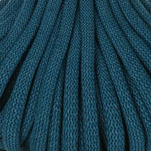 A close-up of dark teal braided cord, filling the entire frame.