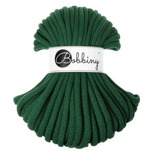 A skein of dark green thick braided cord with a white paper label wrapped around the middle that reads 'Bobbiny' in black script and logo, set against a plain white background.