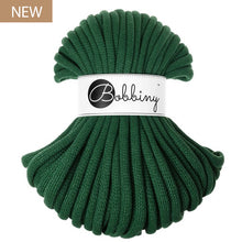 A skein of dark green braided cord with a white paper band around the middle reading 'Bobbiny' in script, shown on a plain white background with a small 'NEW' label in the top-left corner.