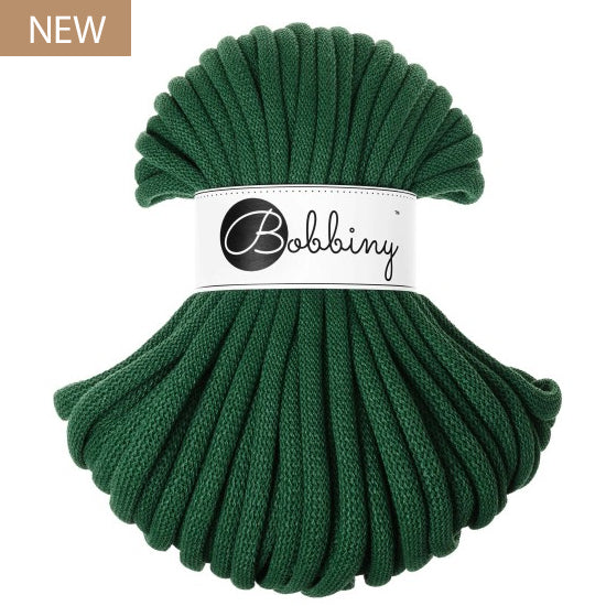 A skein of dark green braided cord with a white paper band around the middle reading 'Bobbiny' in script, shown on a plain white background with a small 'NEW' label in the top-left corner.