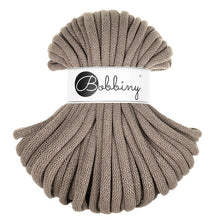 A skein of braided cord in taupe coffee colour, wrapped with a white paper label that reads 'Bobbiny'.