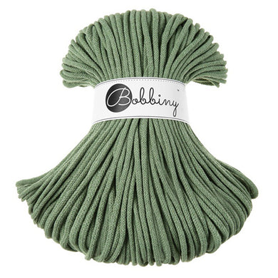 A bundle of eucalyptus green braided cord with a white paper label wrapped around the middle that reads 'Bobbiny'.