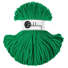 A skein of jade green braided cord or rope with a white paper label wrapped around the center that reads 'Bobbiny'.