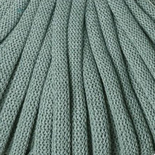 A close-up of a braided cord in a muted sage green color, showing the detailed texture and pattern of the yarn.