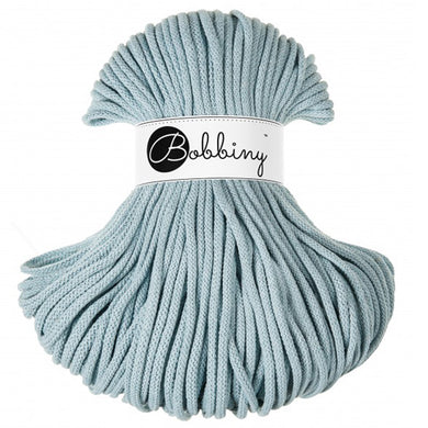 A skein of light blue braided cord with a white paper label wrapped around the middle that reads 'Bobbiny'.
