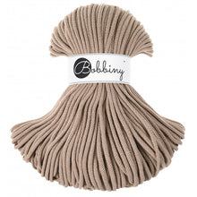 A bundle of thick, braided sand cord with a white paper label wrapped around the middle that reads 'Bobbiny'.