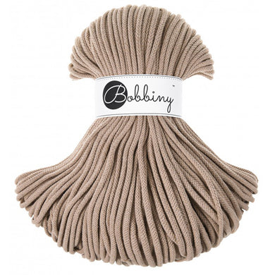 A bundle of thick, braided sand cord with a white paper label wrapped around the middle that reads 'Bobbiny'.
