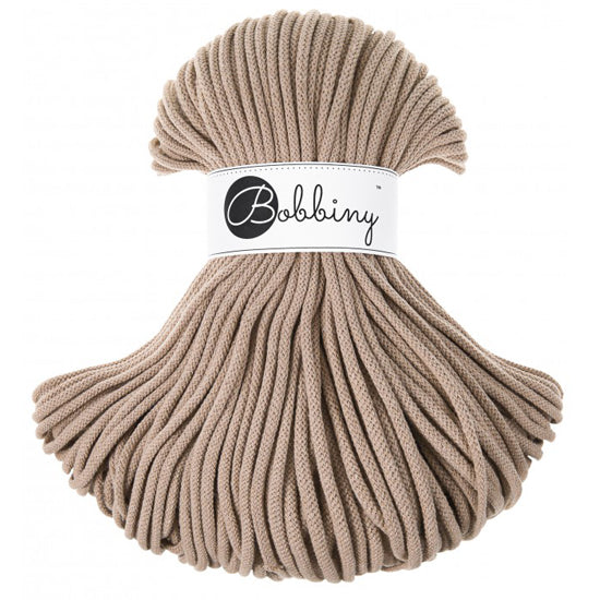 A bundle of thick, braided sand cord with a white paper label wrapped around the middle that reads 'Bobbiny'.